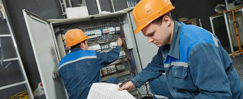 Commercial electrician performing electrical installations, inspecting high voltage switchboards, and ensuring proper wiring and circuit breakers