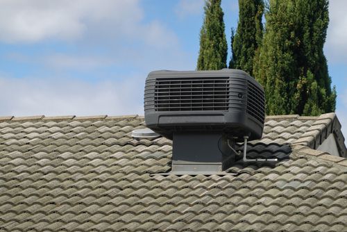 Electrician servicing an evaporative air conditioning unit, ensuring proper electrical wiring and safe installation