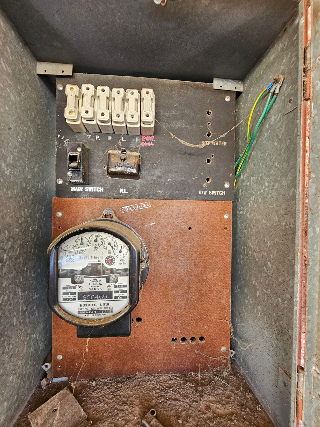 Old switchboard inspected by an electrician for electrical safety.