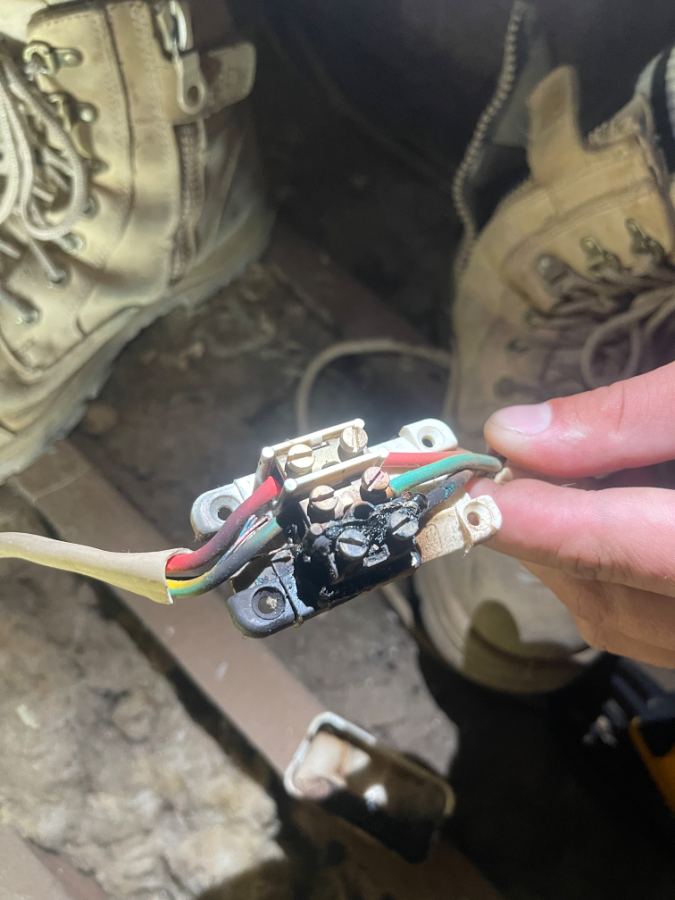 Burnt wiring junction inspected by electrician to address faults and improve electrical safety
